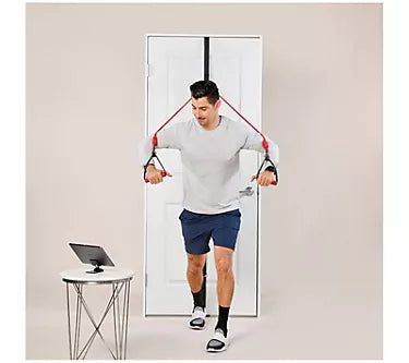 Person using a door anchor exercise system with resistance bands in front of a mirror.